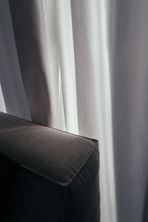 Cozy living room with dark blackout curtains softly filtering daylight.