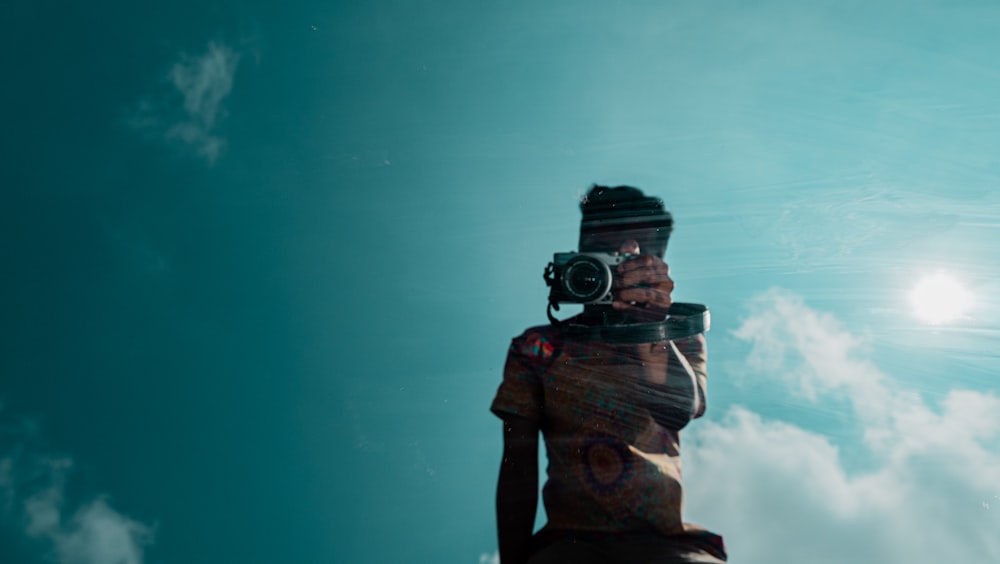 man in black jacket holding black dslr camera