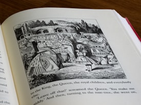 An open book displays an illustration depicting a young girl standing among a diverse group of characters in an imaginative setting. The artwork features intricate line work, showcasing various figures in costumes with expressive faces, likely from a fantasy or whimsical story. Trees and a waterfall provide a natural backdrop to the scene.