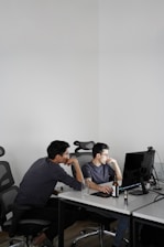 2 men sitting on black office rolling chairs