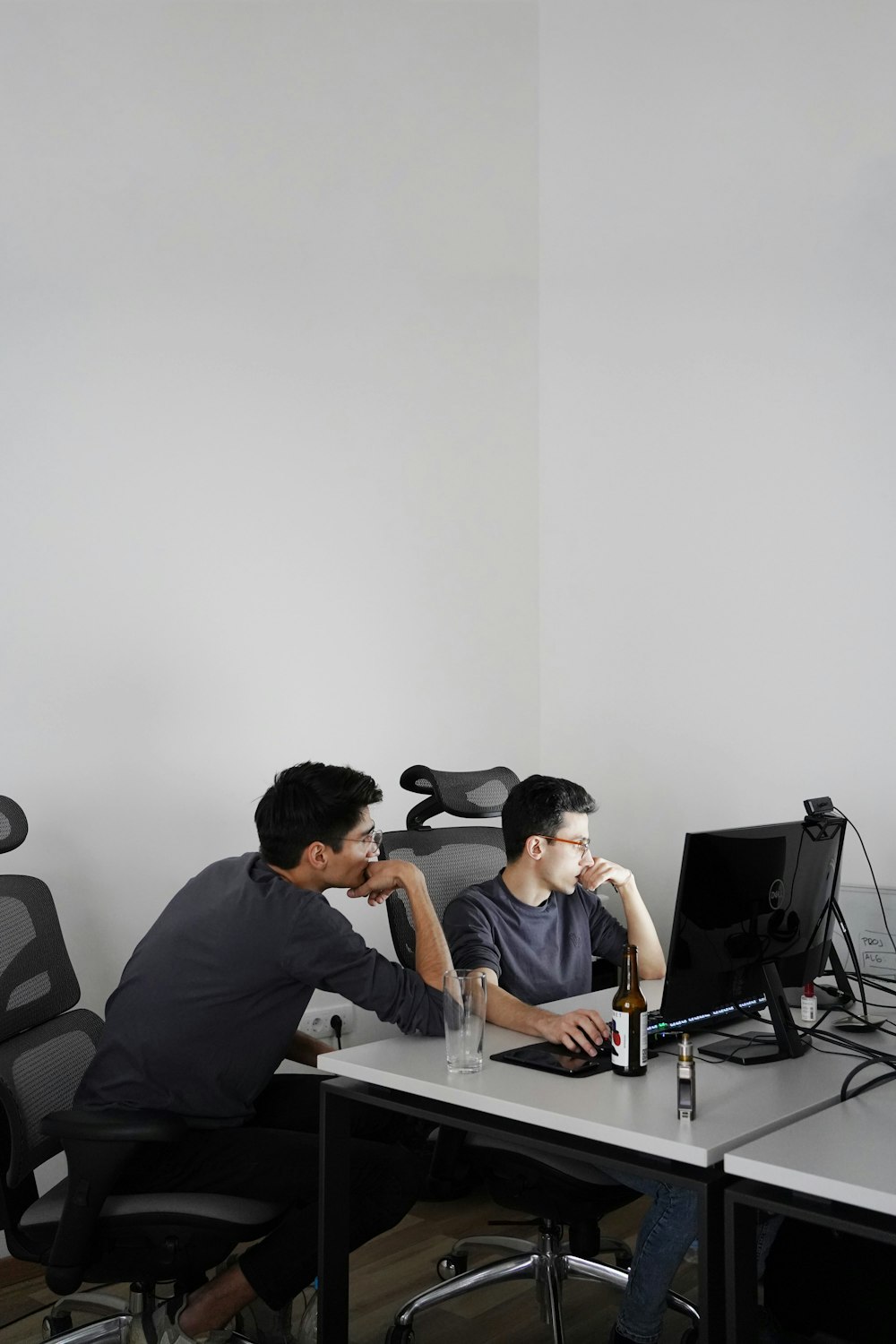 2 men sitting on black office rolling chairs