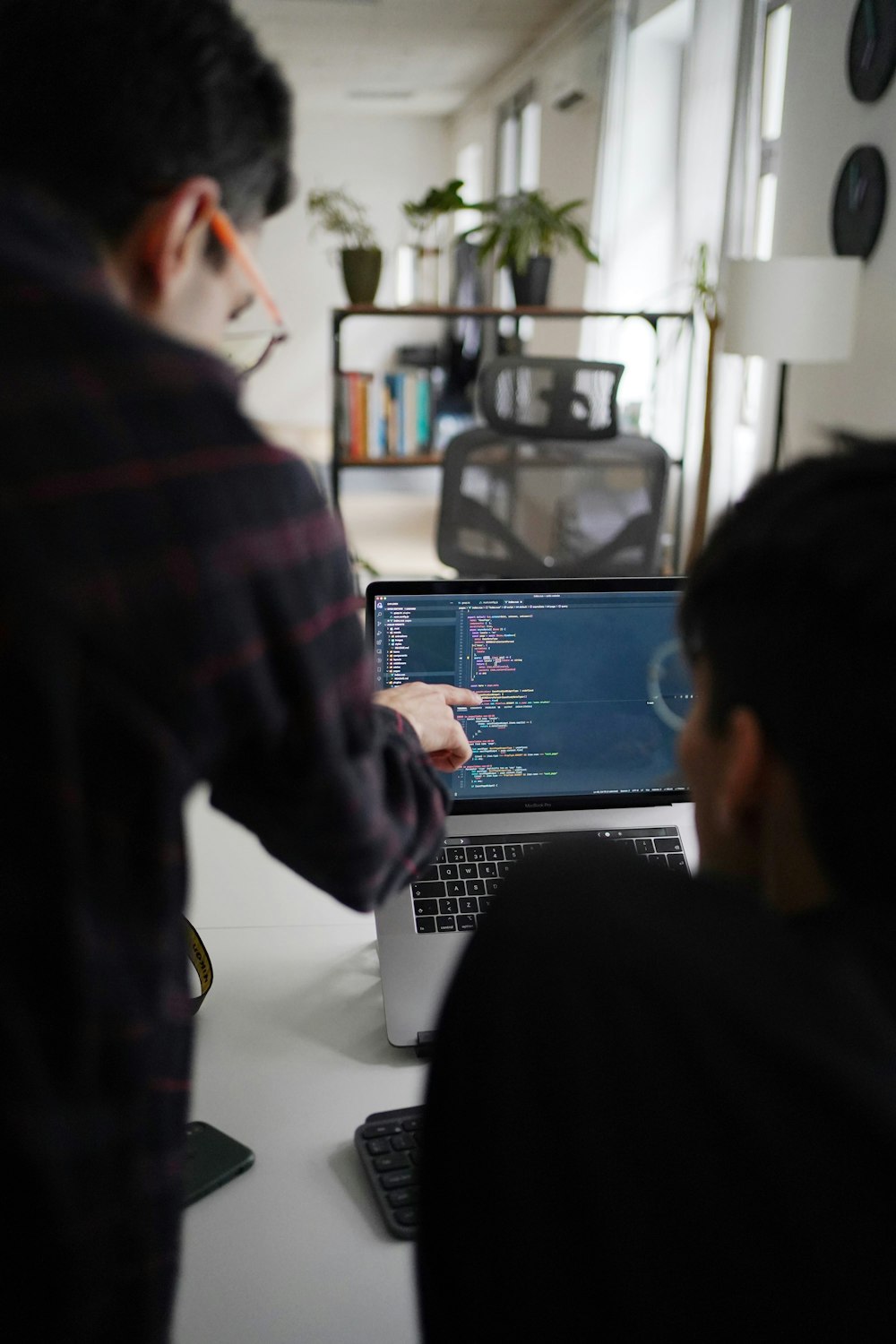 man in black and red plaid shirt using black and gray laptop computer