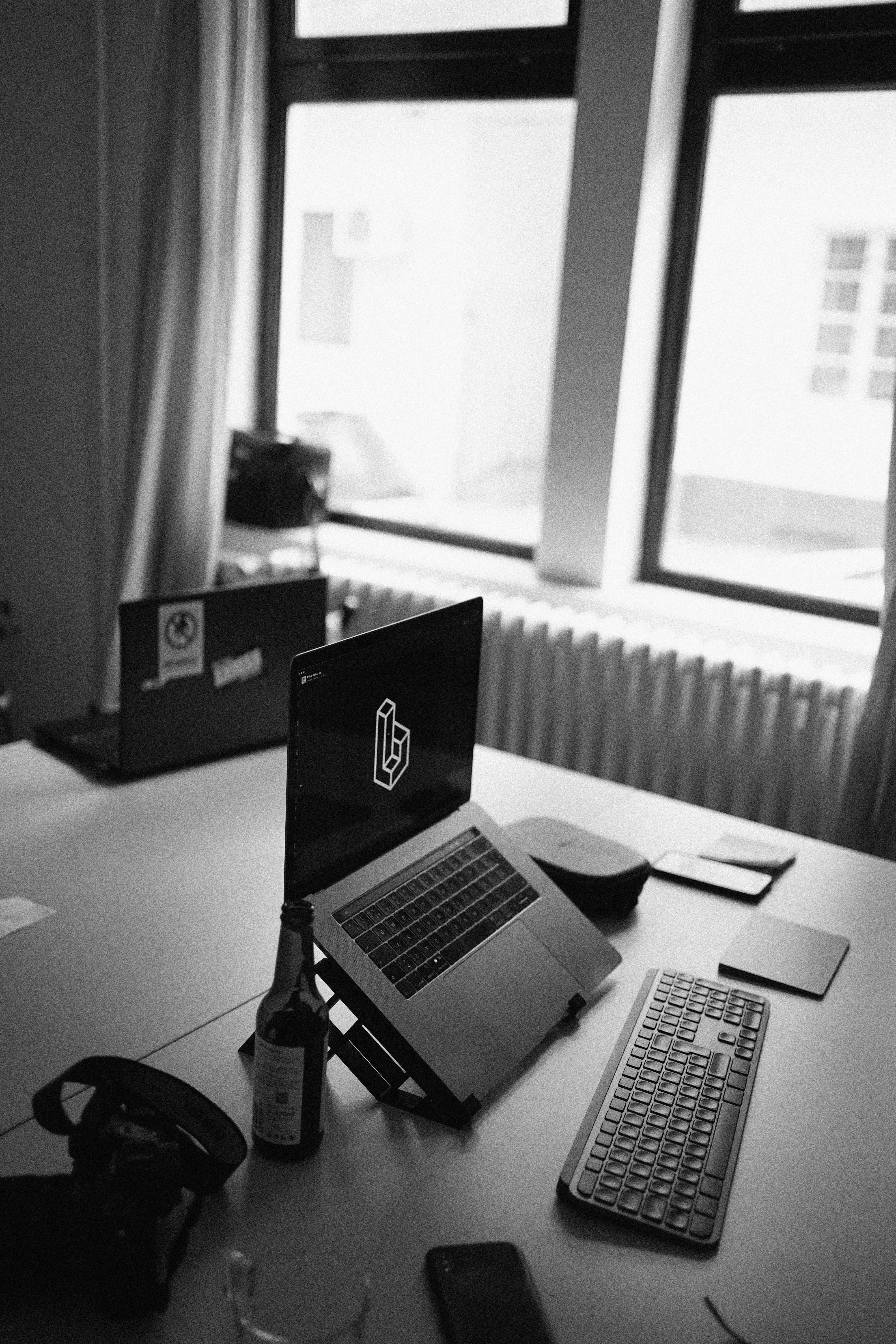 grayscale photo of macbook pro on table