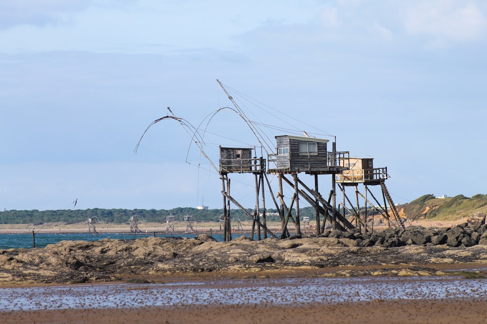 torre de metal marrom e branca perto do corpo de água durante o dia