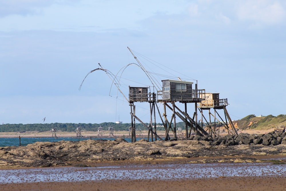 brown and white metal tower near body of water during daytime