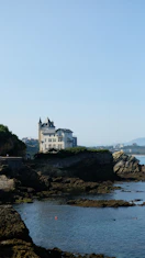 A stunning mansion overlooking a sparkling coastline at sunset.