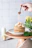 Close-up of a glass jar filled with golden handcrafted syrup drizzling over pancakes.
