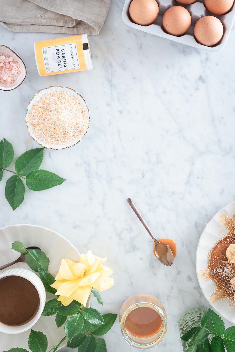 white and yellow flower beside white ceramic bowl with brown powder