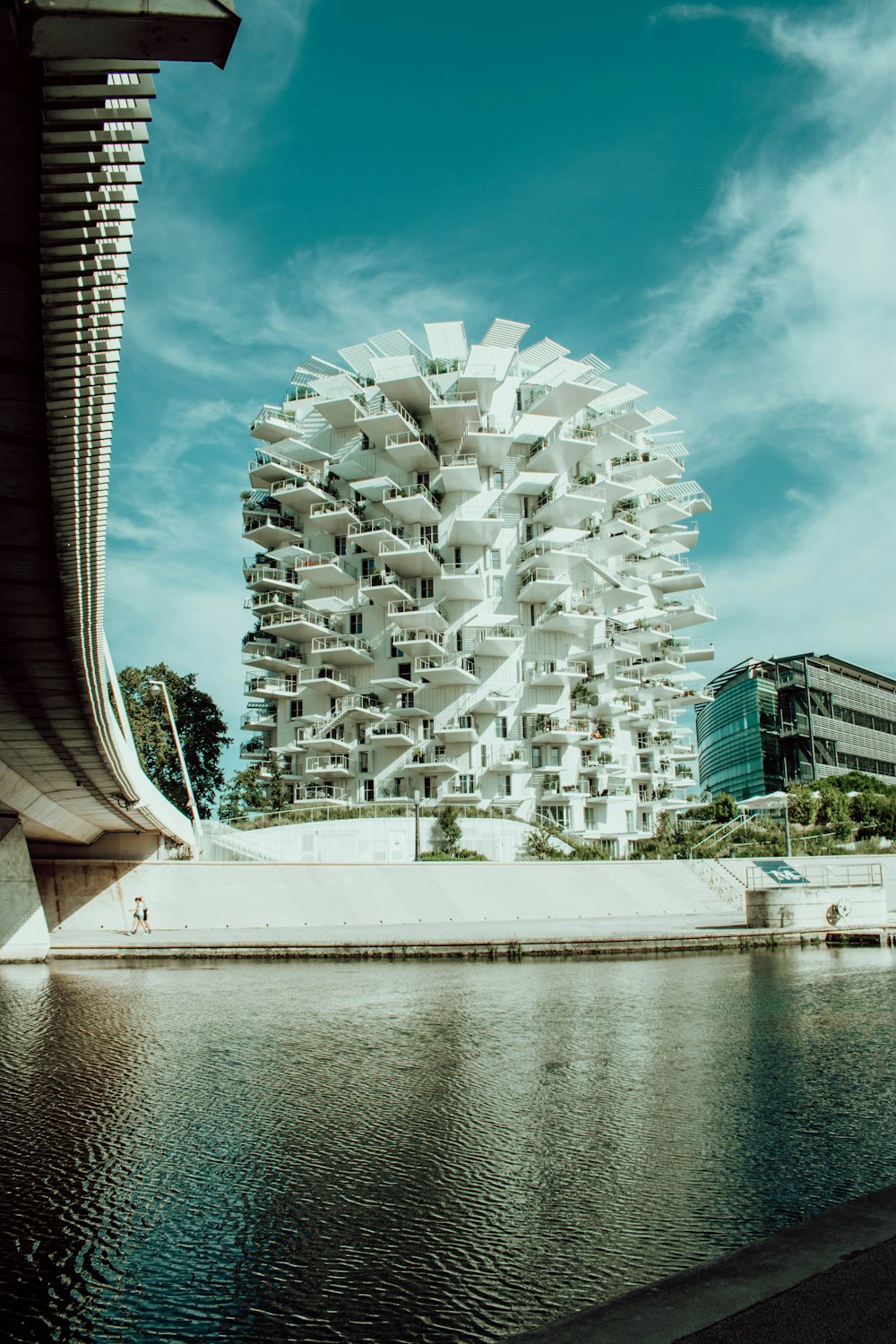 Bâtiment en béton blanc près d’un plan d’eau pendant la journée