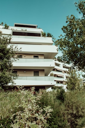 white concrete building near green trees during daytime