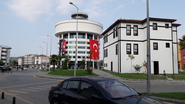 Modern office building in Istanbul with a Turkish flag flying nearby.