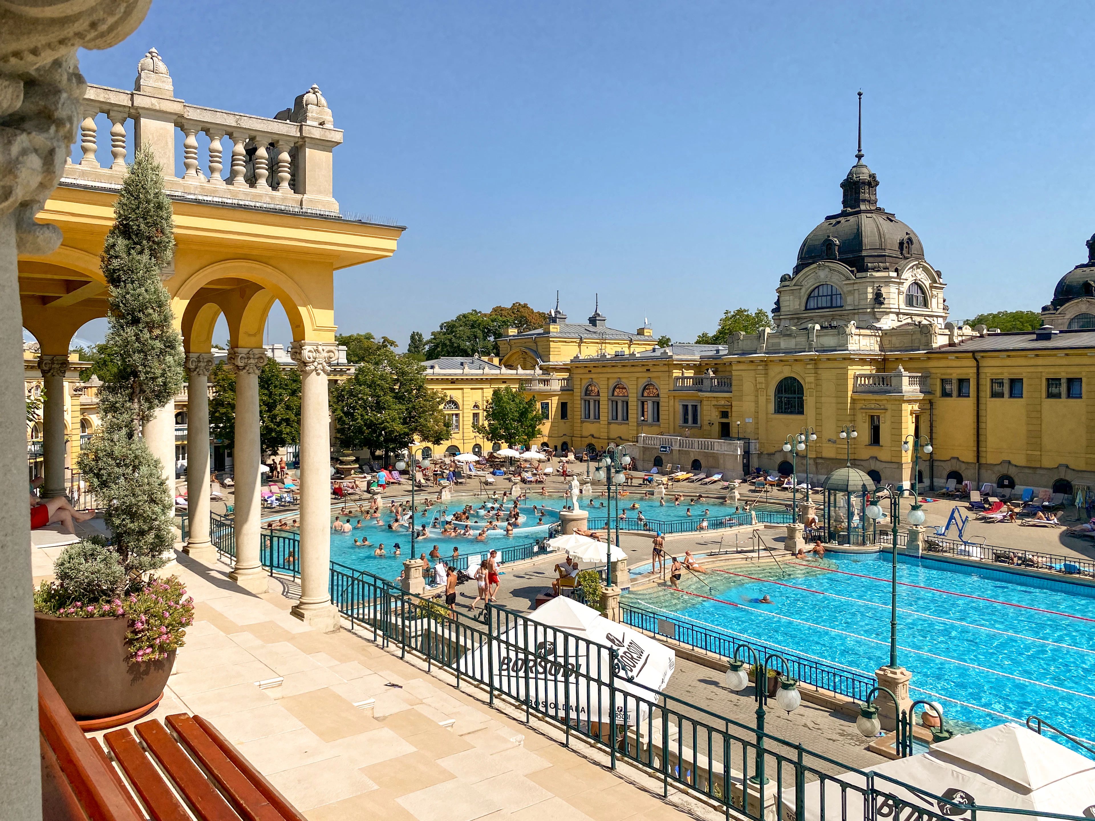 An arched terrace overlooks the full Szechenyi bath complex and its ochre palace facade.