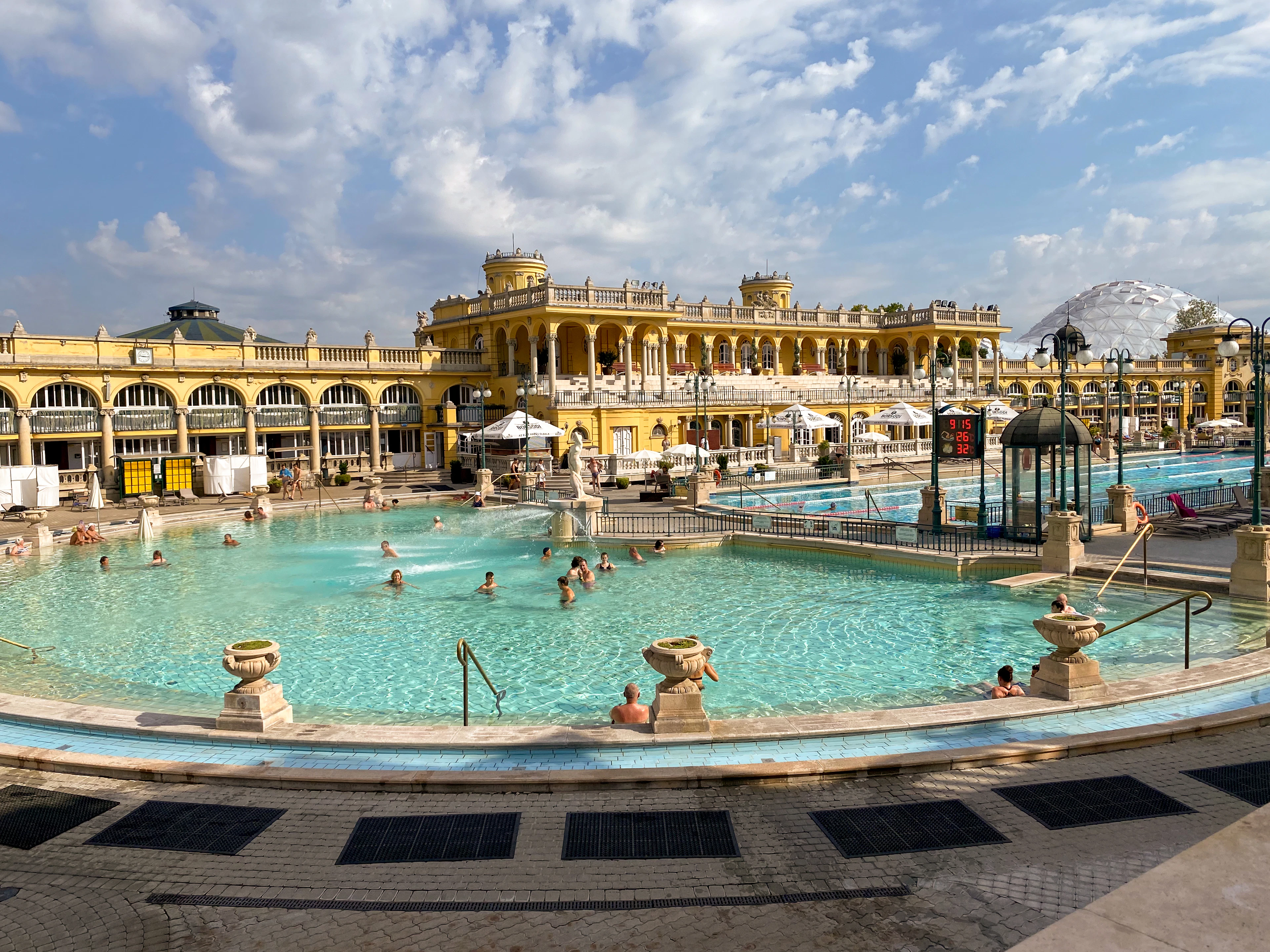 The outdoor pool at the Szechenyi baths in Budapest, bathers in the steam under the ochre palace facade