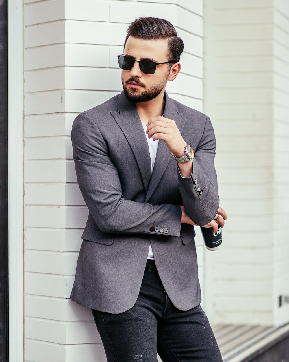 Hombre con chaqueta de traje gris con gafas de sol negras