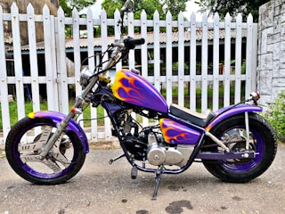 A custom motorcycle with unique paint and accessories displayed outdoors.