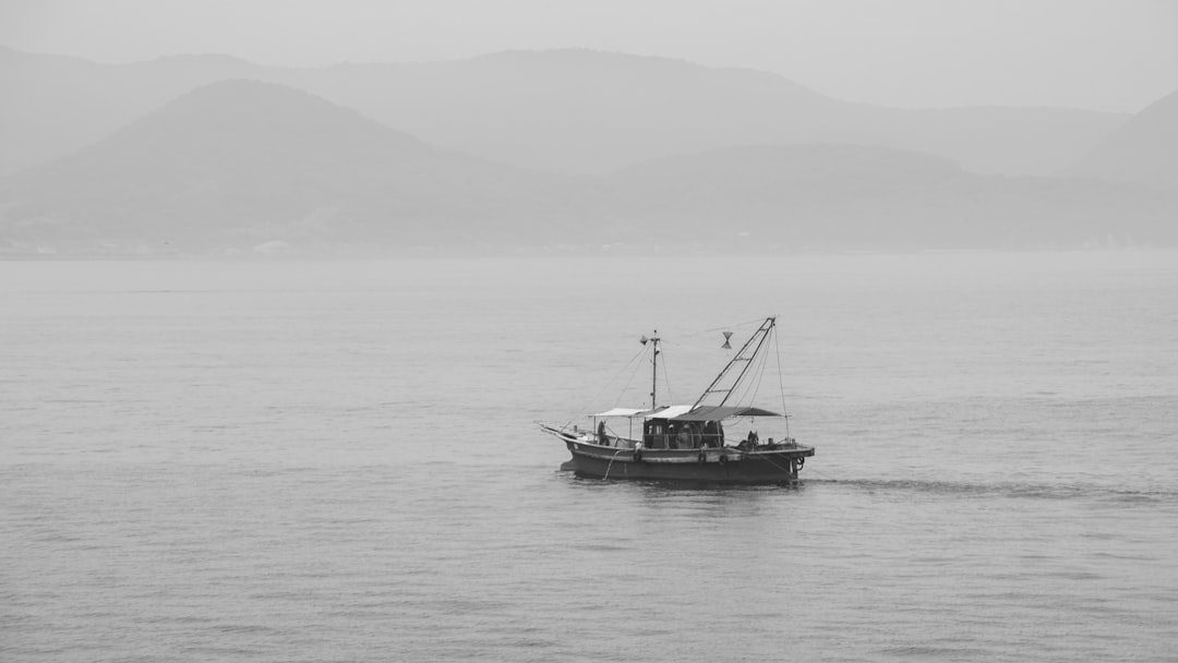 black boat on body of water during daytime