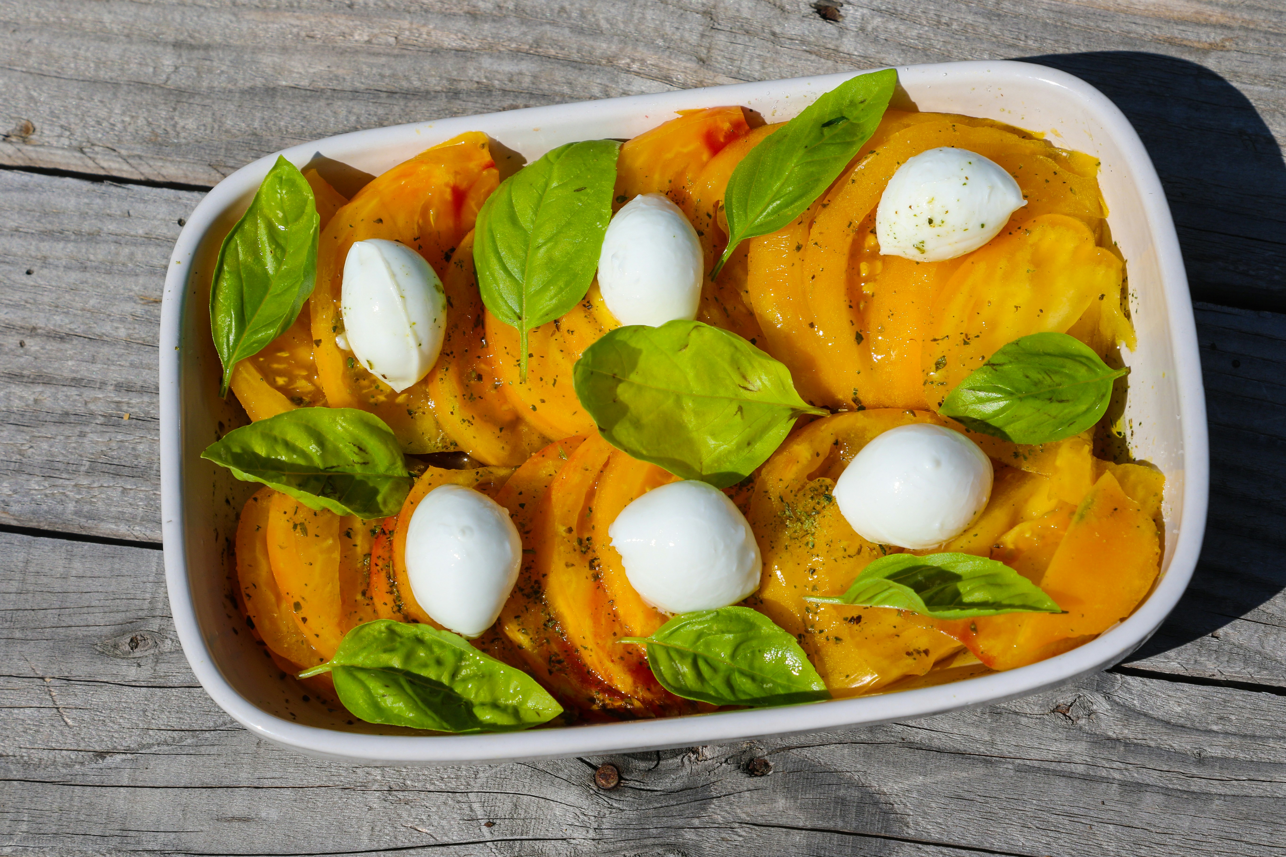 sliced tomato and green vegetable on white ceramic plate