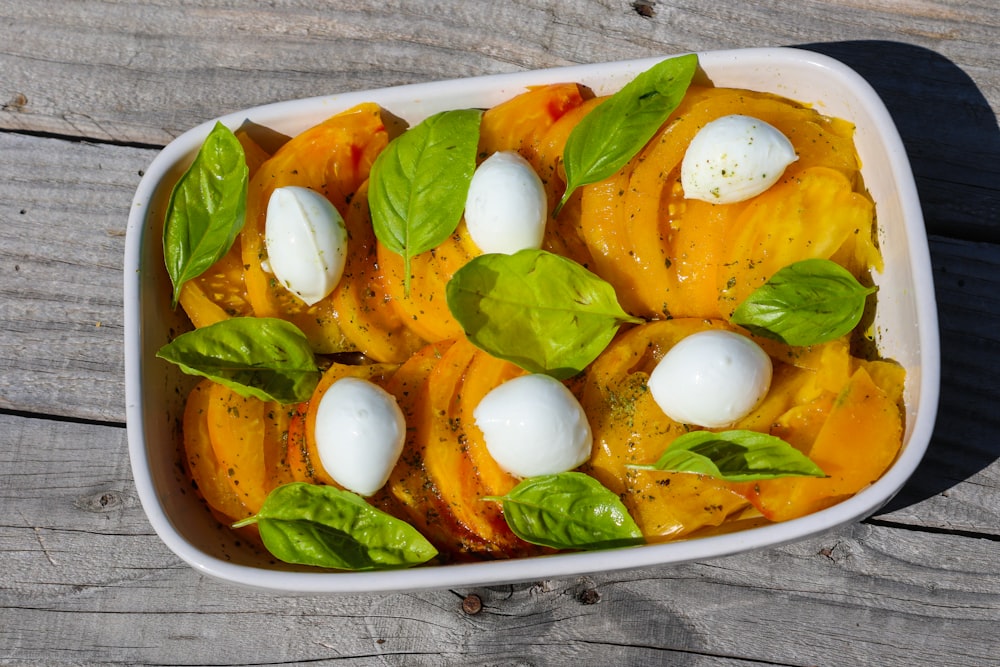 rodajas de tomate y verdura verde en plato de cerámica blanca