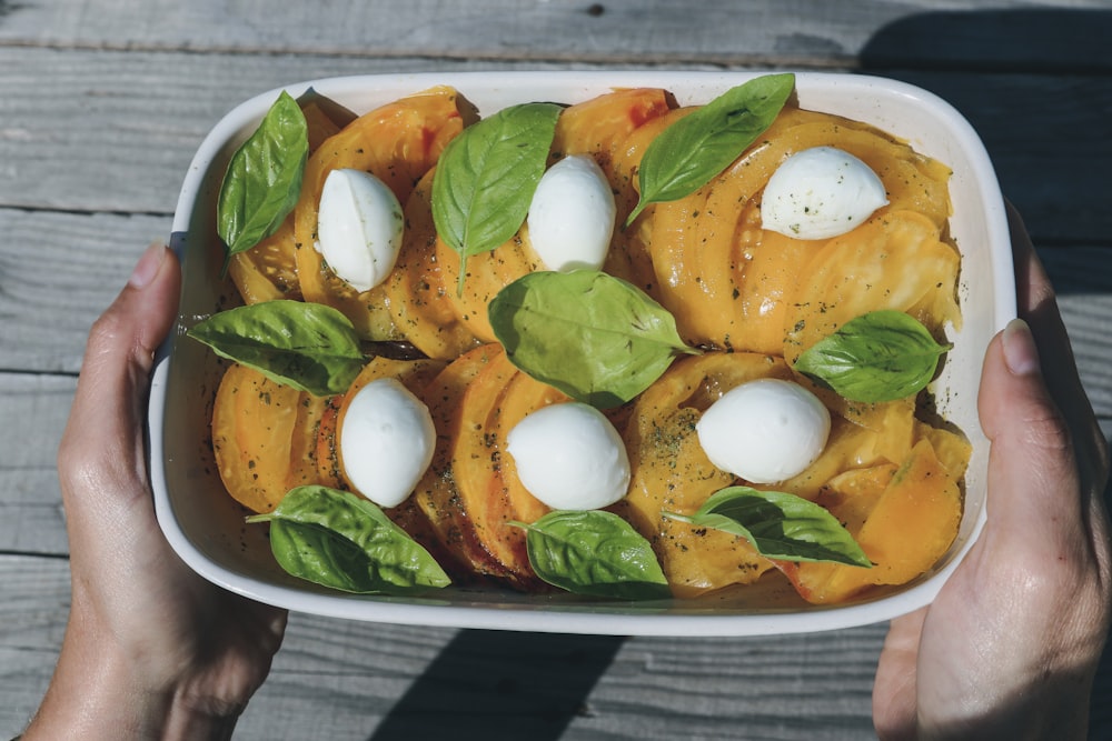 rodajas de tomate y verdura verde en plato de cerámica blanca