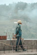 man in blue jacket and white helmet standing on brown wooden dock during daytime