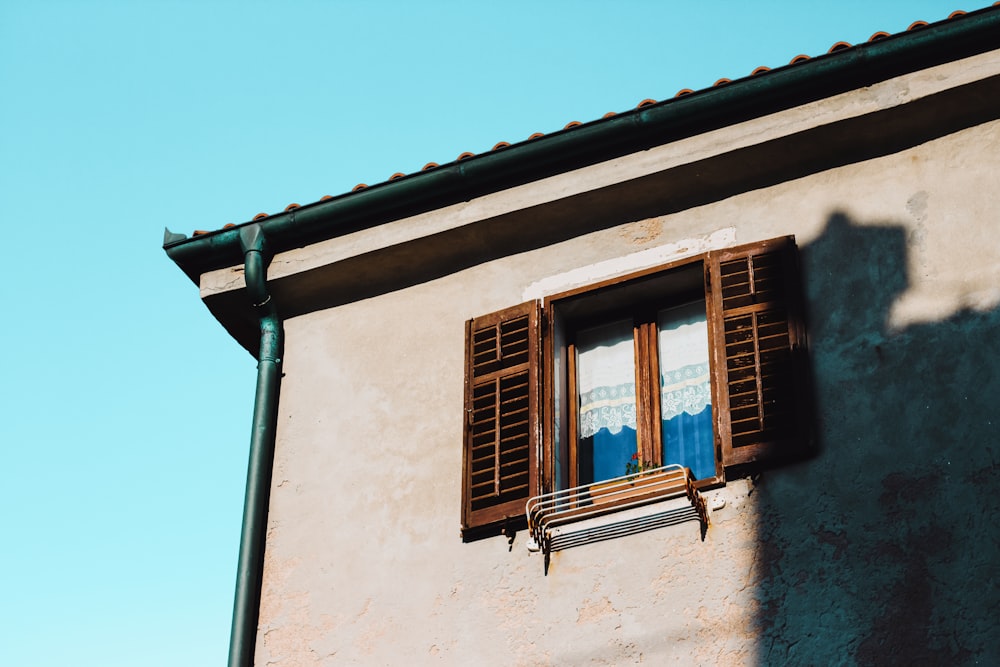 brown wooden window frame on white concrete wall