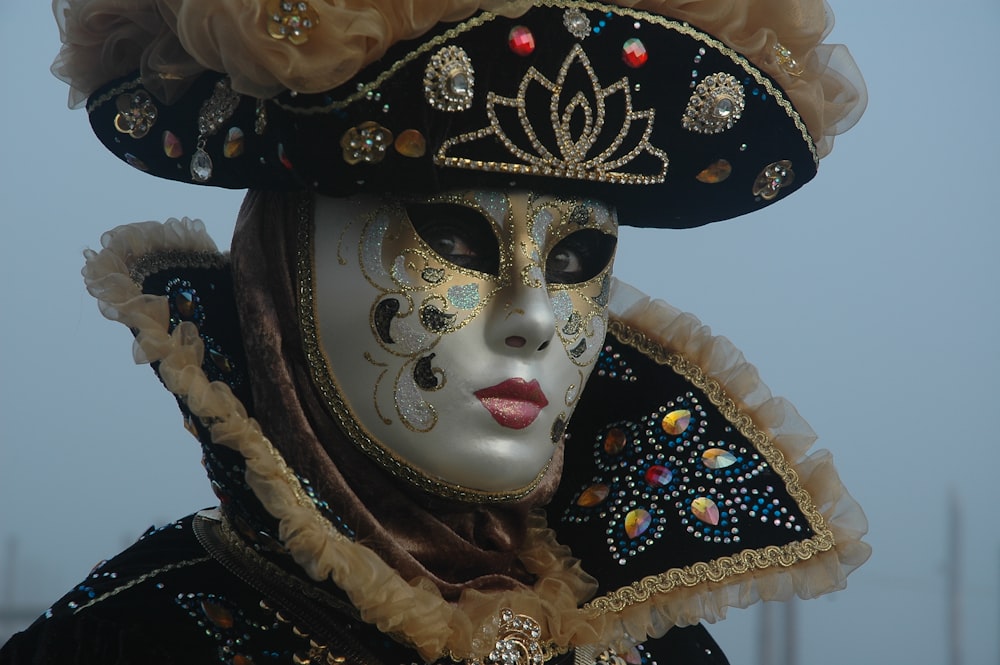 person wearing white and gold mask