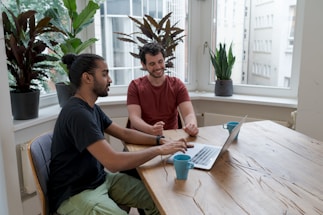 A friendly SEO specialist discussing strategies with a flooring store owner in a bright office.