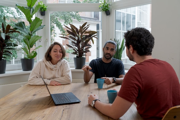 woman in white hijab sitting beside man in red crew neck t-shirt