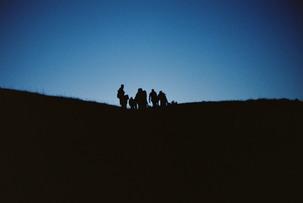 silhouette de personnes sur la montagne pendant la nuit