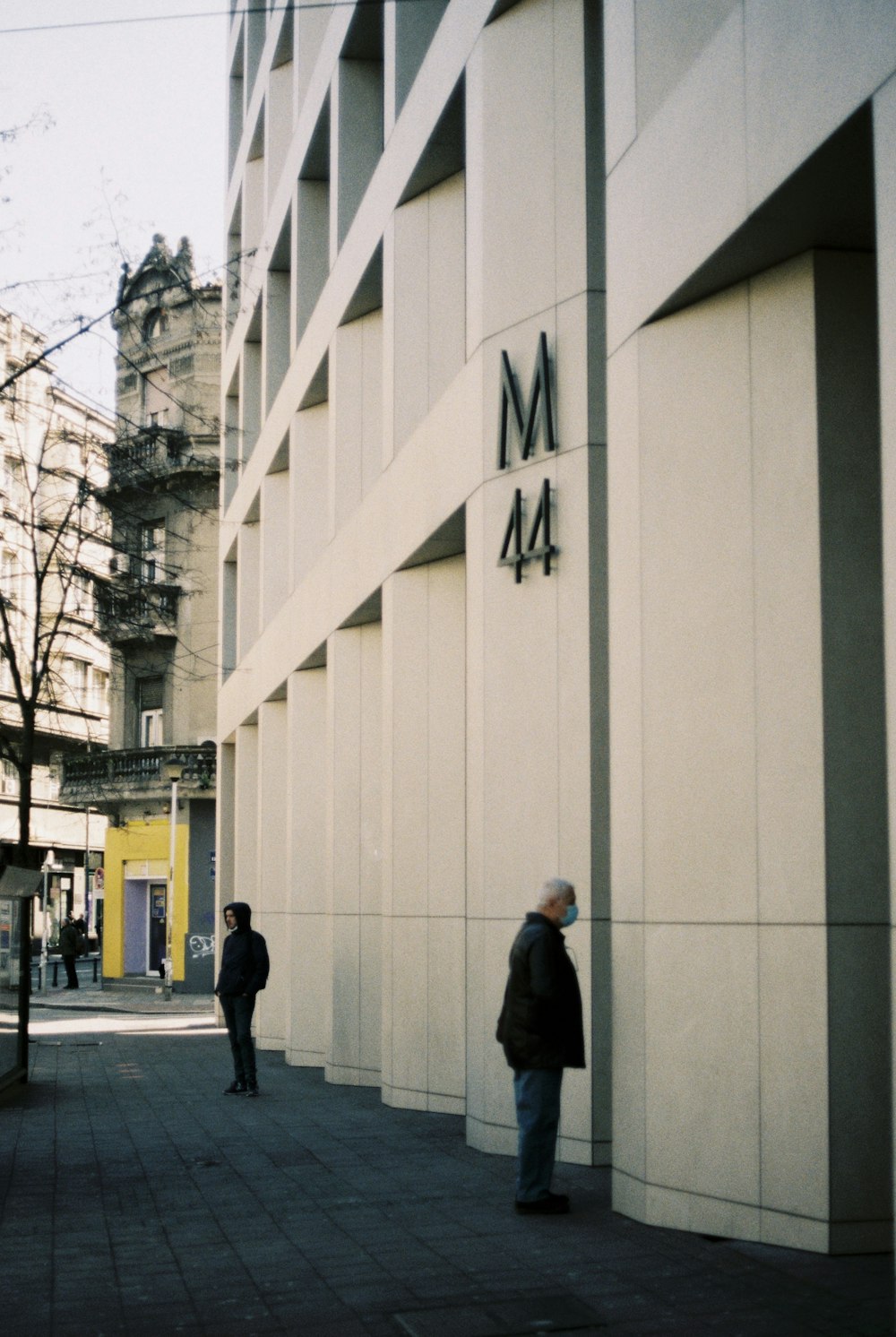 man in black jacket walking on sidewalk during daytime