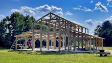 brown wooden building on green grass field during daytime