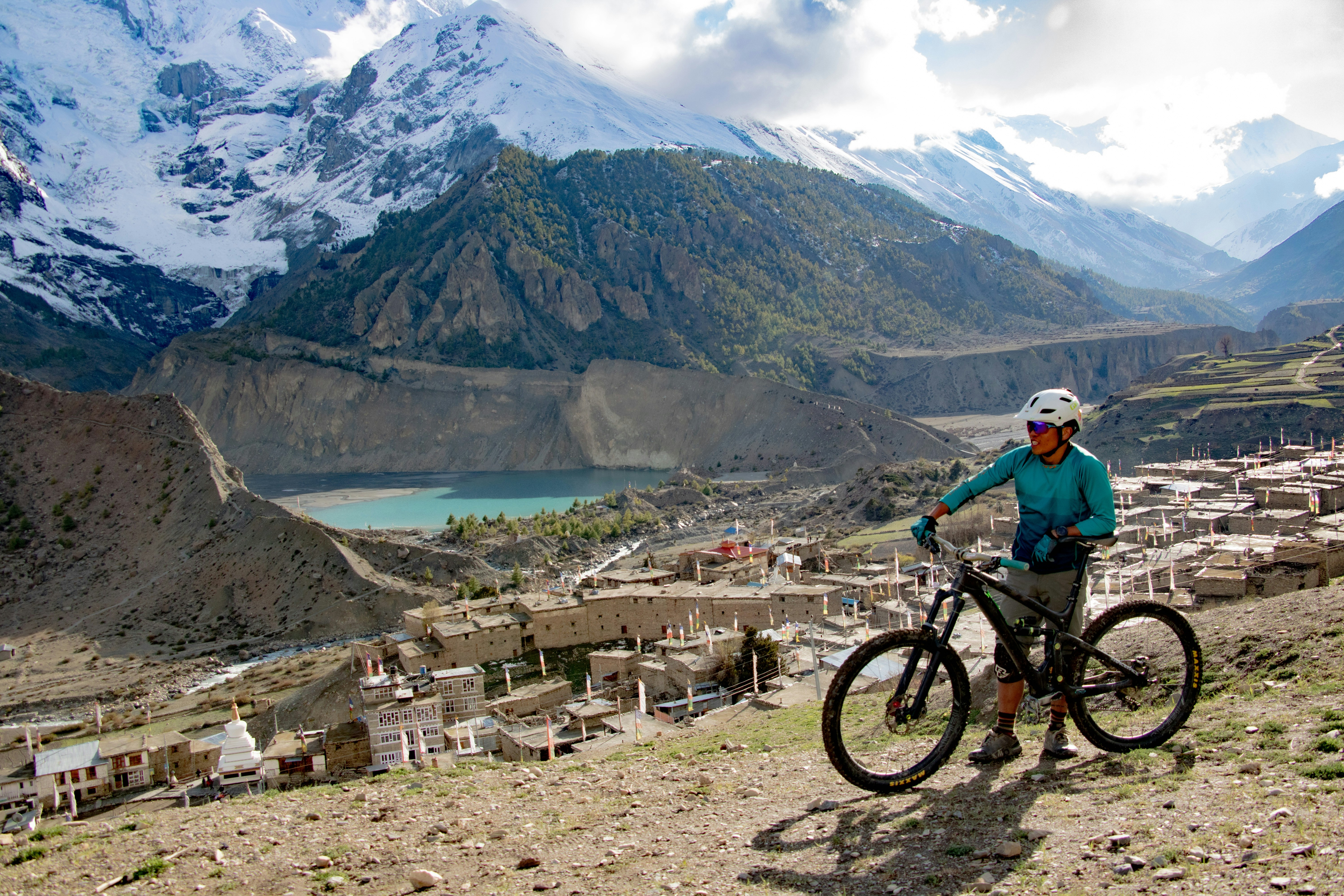man in green shirt riding bicycle on mountain during daytime