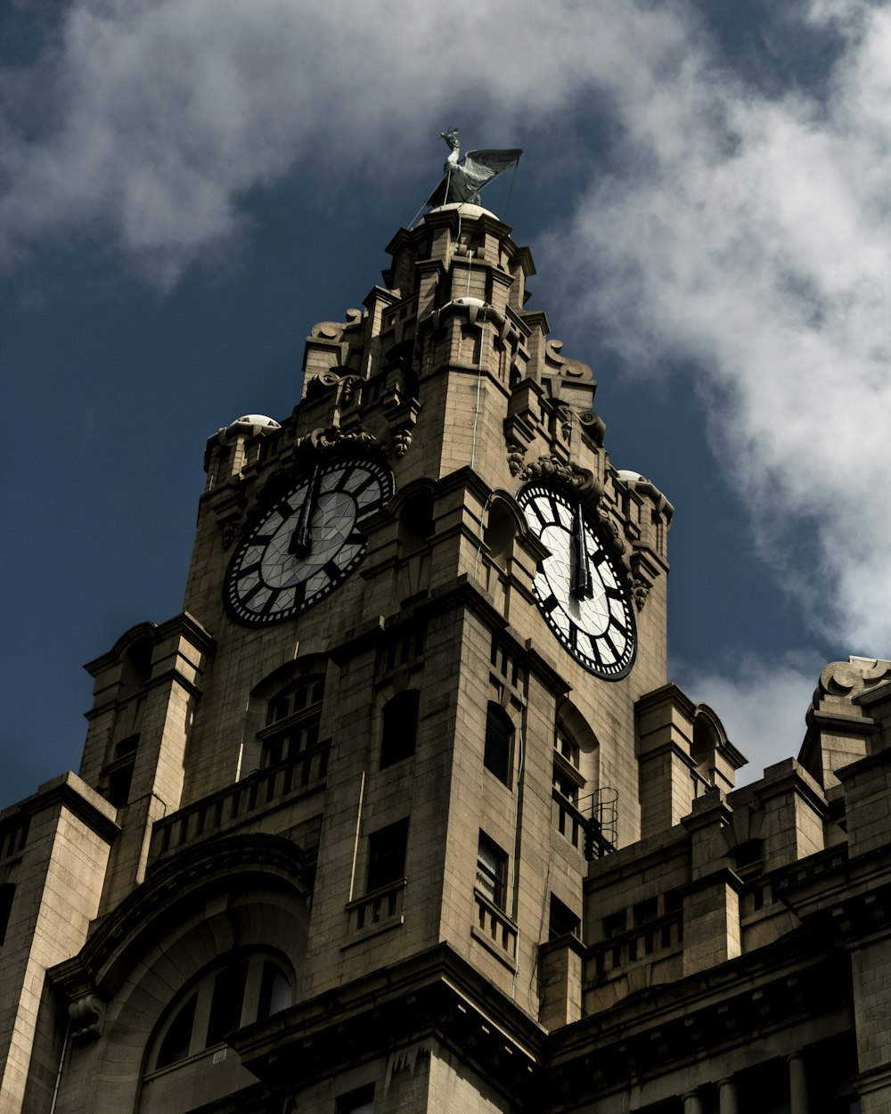 brown concrete building with clock under blue sky during daytime