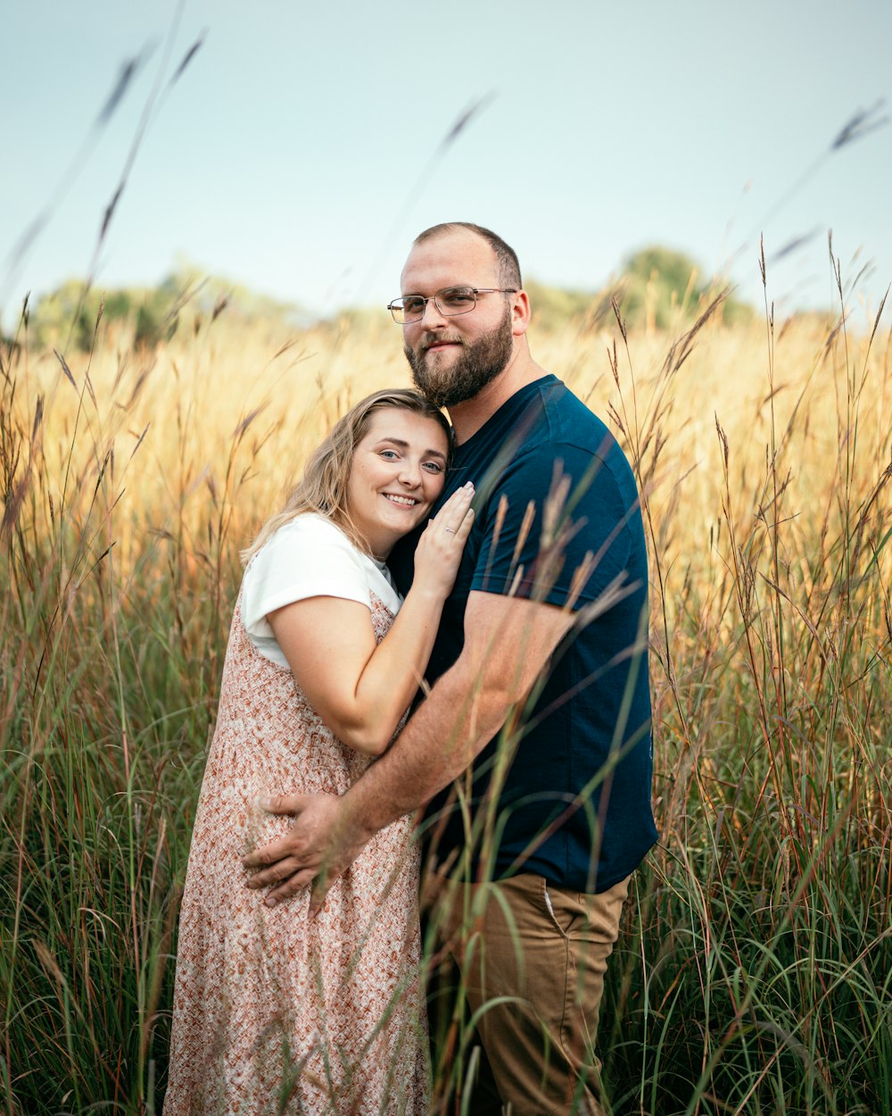 man in blue and brown long sleeve shirt hugging woman in brown dress