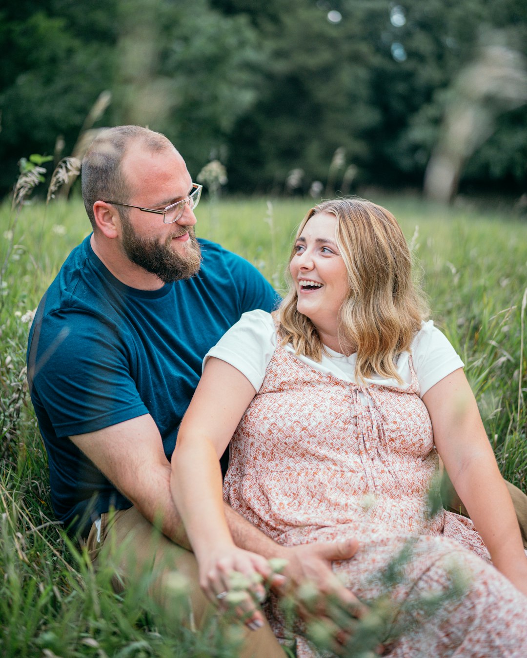 man in blue crew neck t-shirt kissing woman in pink and white floral dress