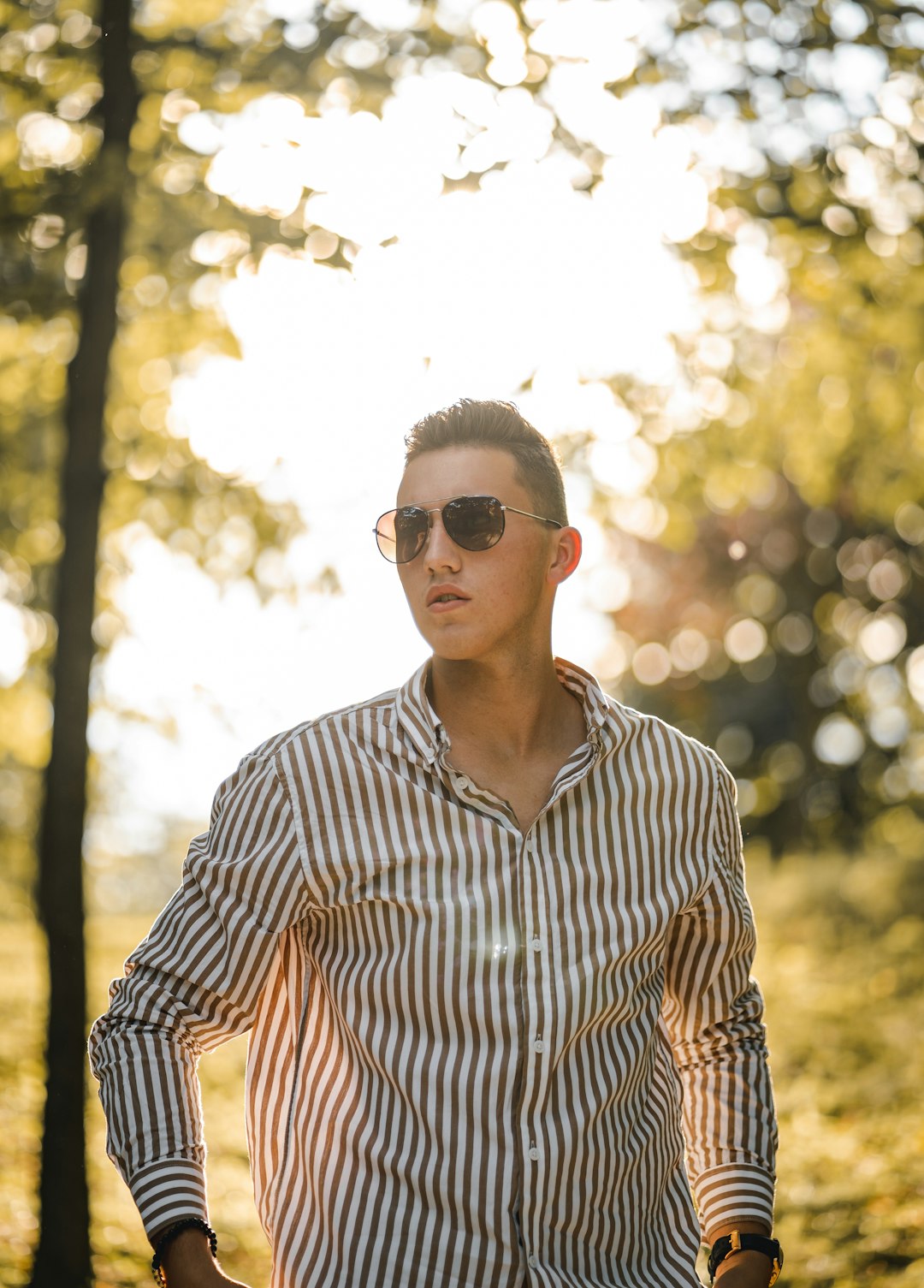 man in black and white striped button up shirt wearing black sunglasses