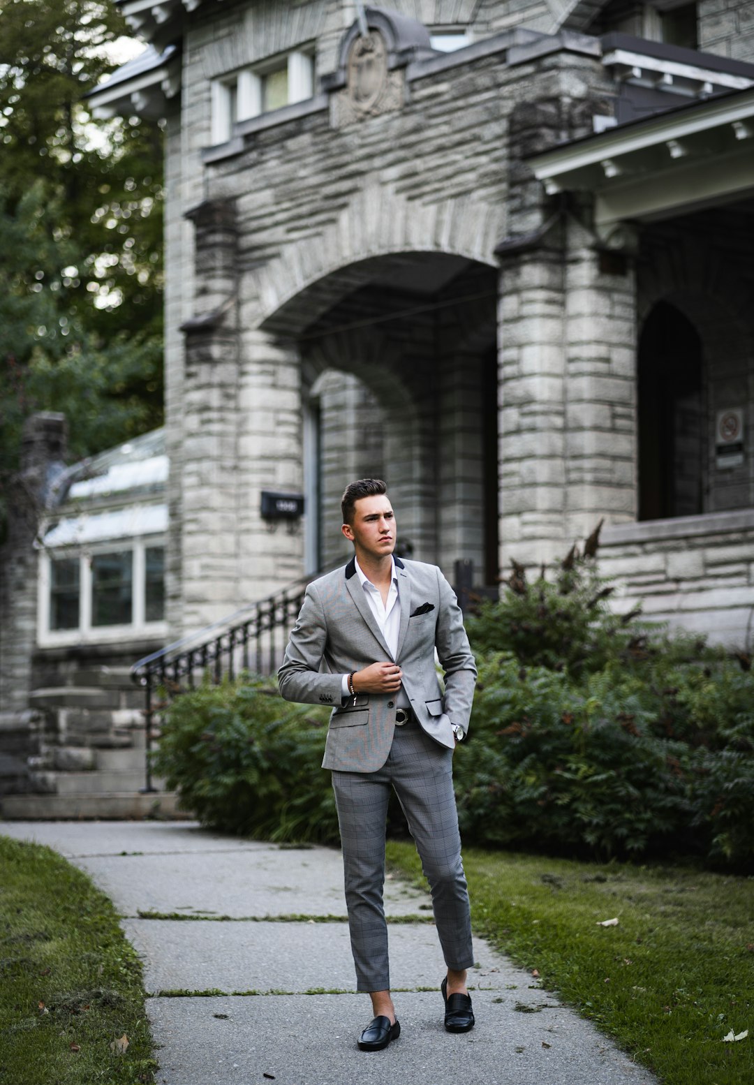 man in gray suit standing on gray concrete pathway during daytime