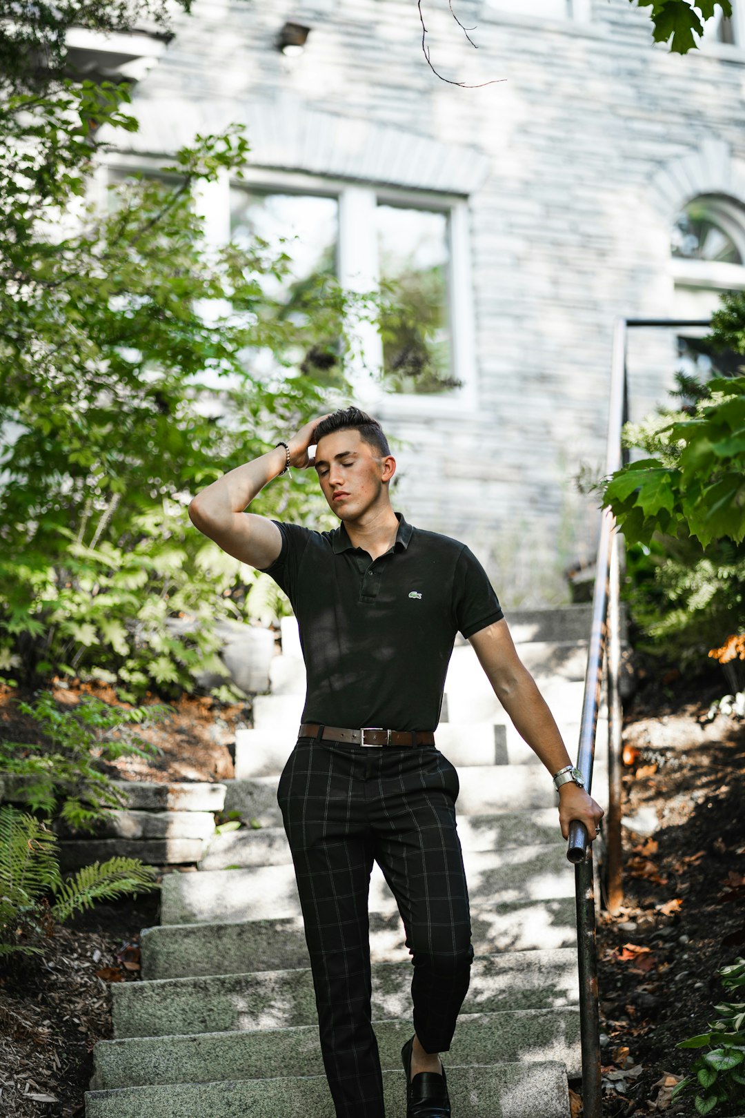 man in black crew neck t-shirt and black pants standing near green plants during daytime