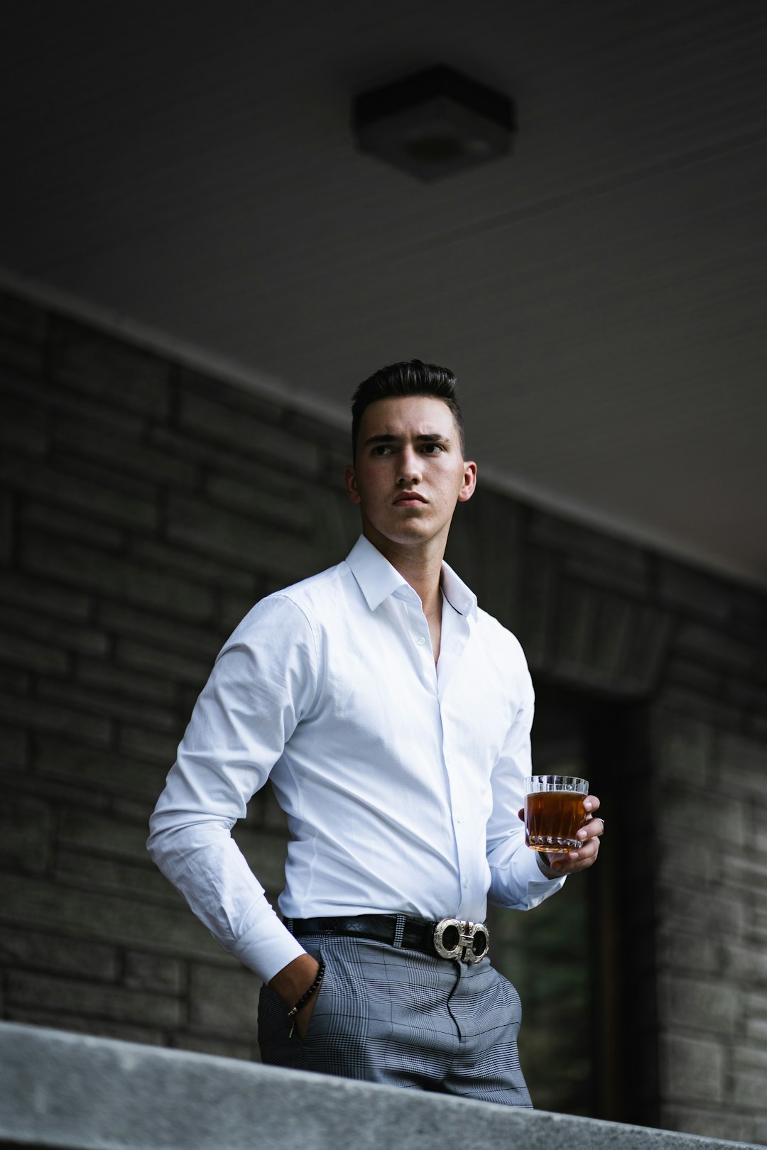 man in white dress shirt holding clear drinking glass