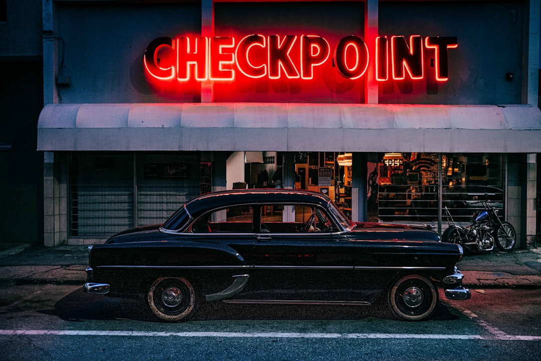 black classic car parked near red and white UNKs store