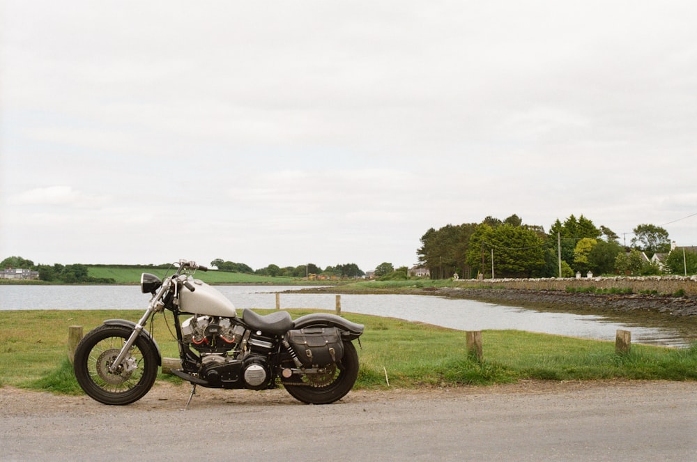 black motorcycle parked on gray concrete road during daytime