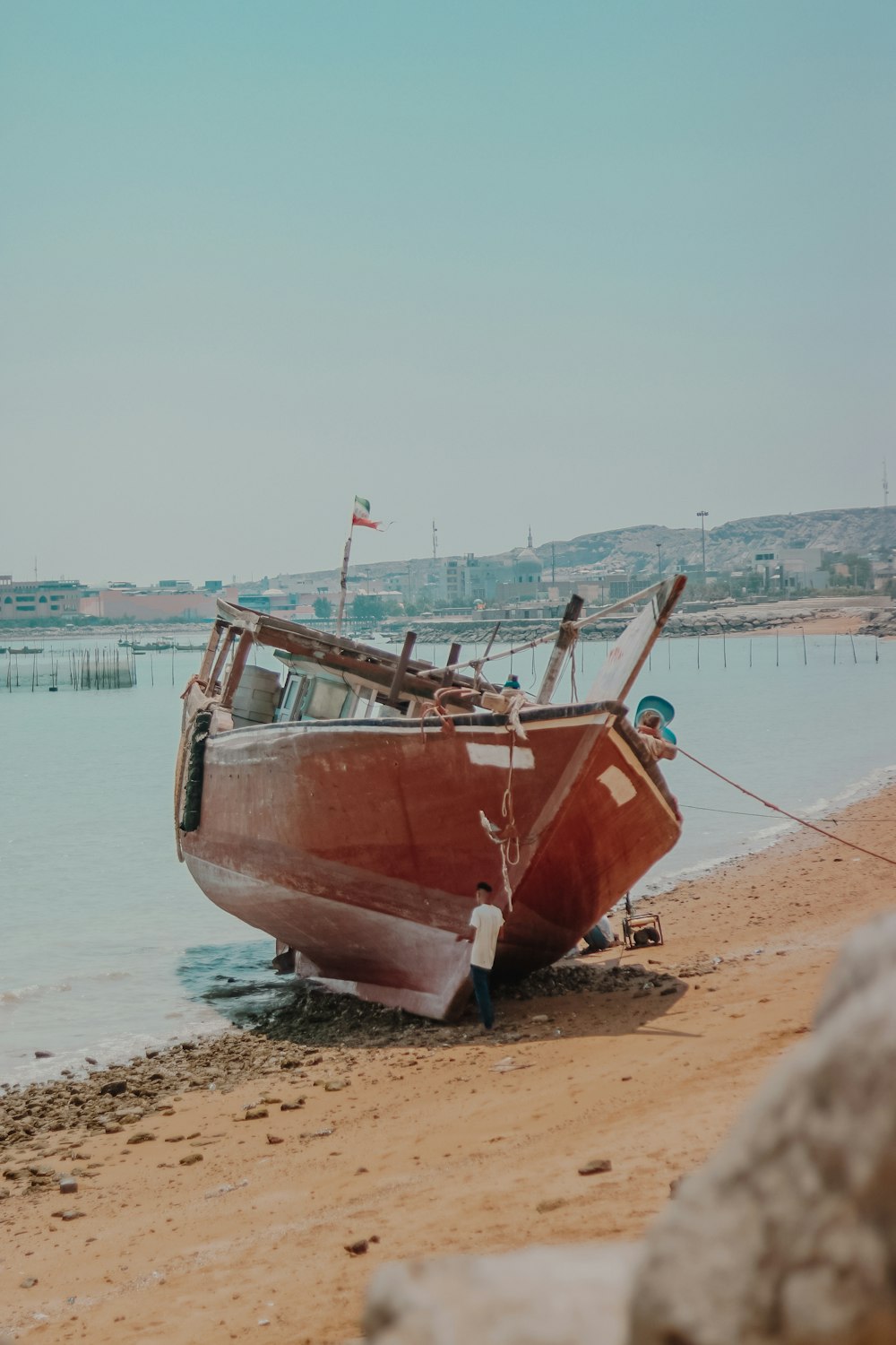 Barco marrón y blanco en la playa durante el día