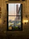 Elegant hotel room with a large window overlooking a vibrant city plaza at sunset.