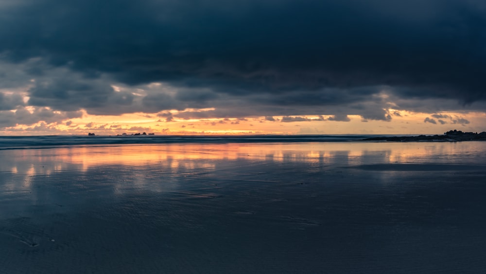 body of water under cloudy sky during daytime