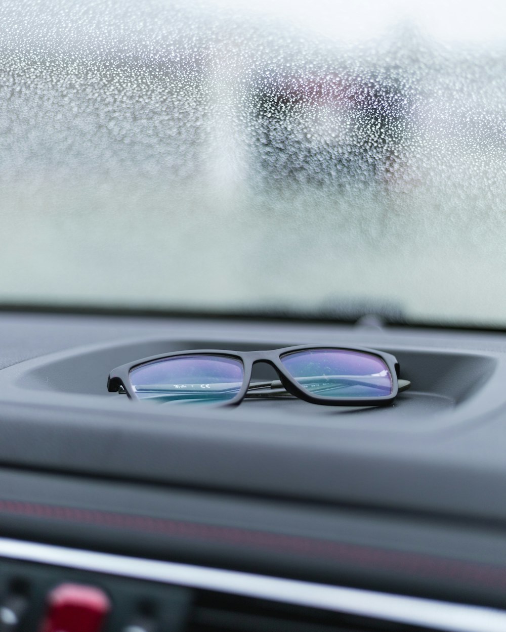 black framed eyeglasses on car dashboard