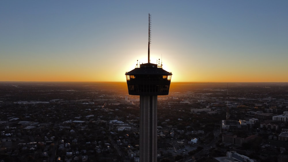 torre preta e branca durante o pôr do sol