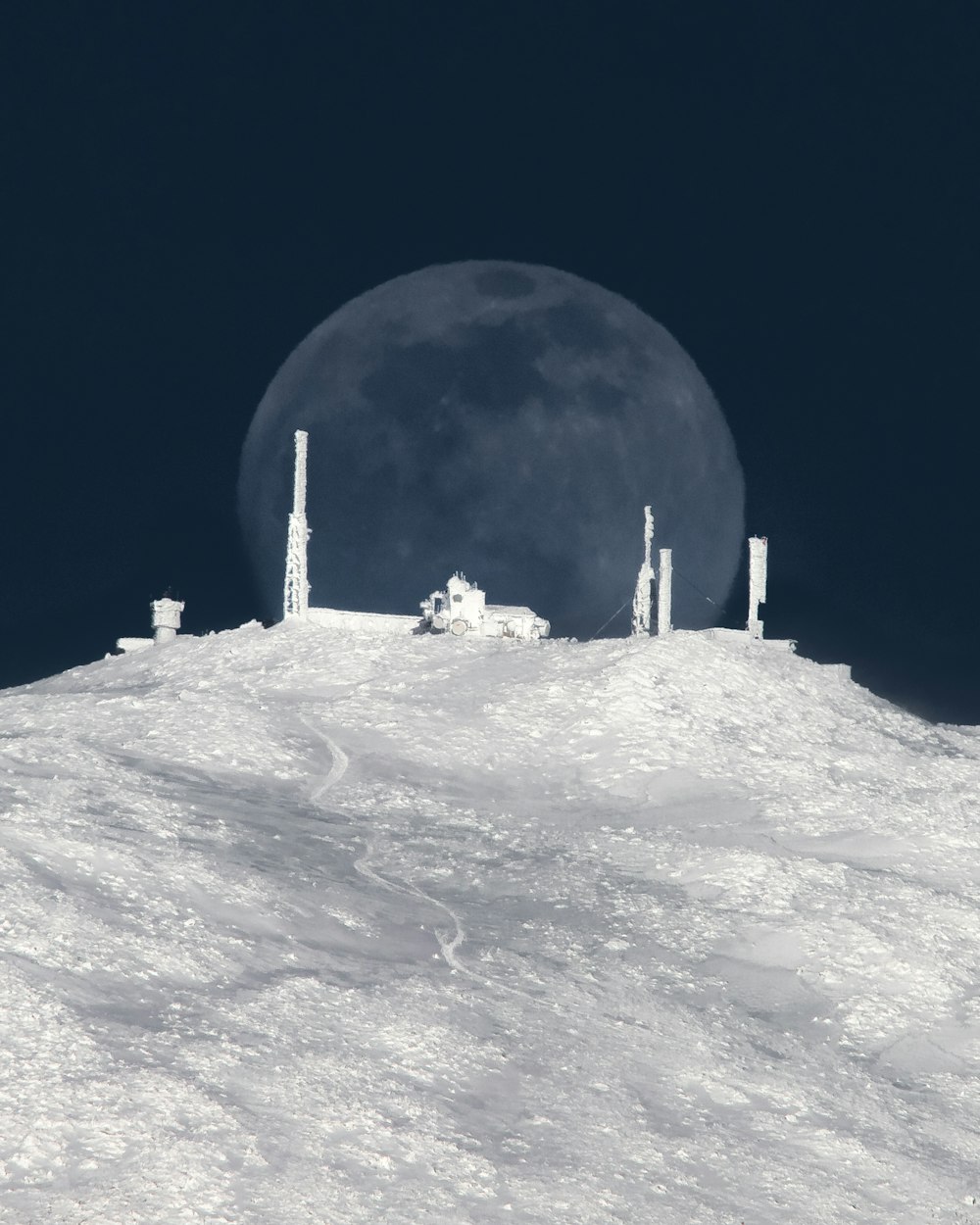 bâtiment blanc et gris sur la montagne couverte de neige blanche pendant la nuit