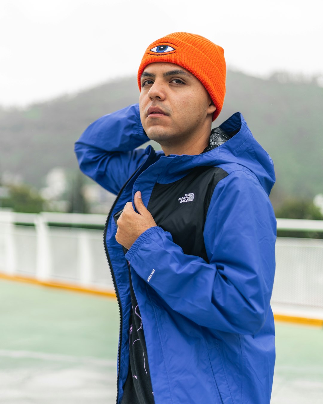 man in blue jacket and orange knit cap