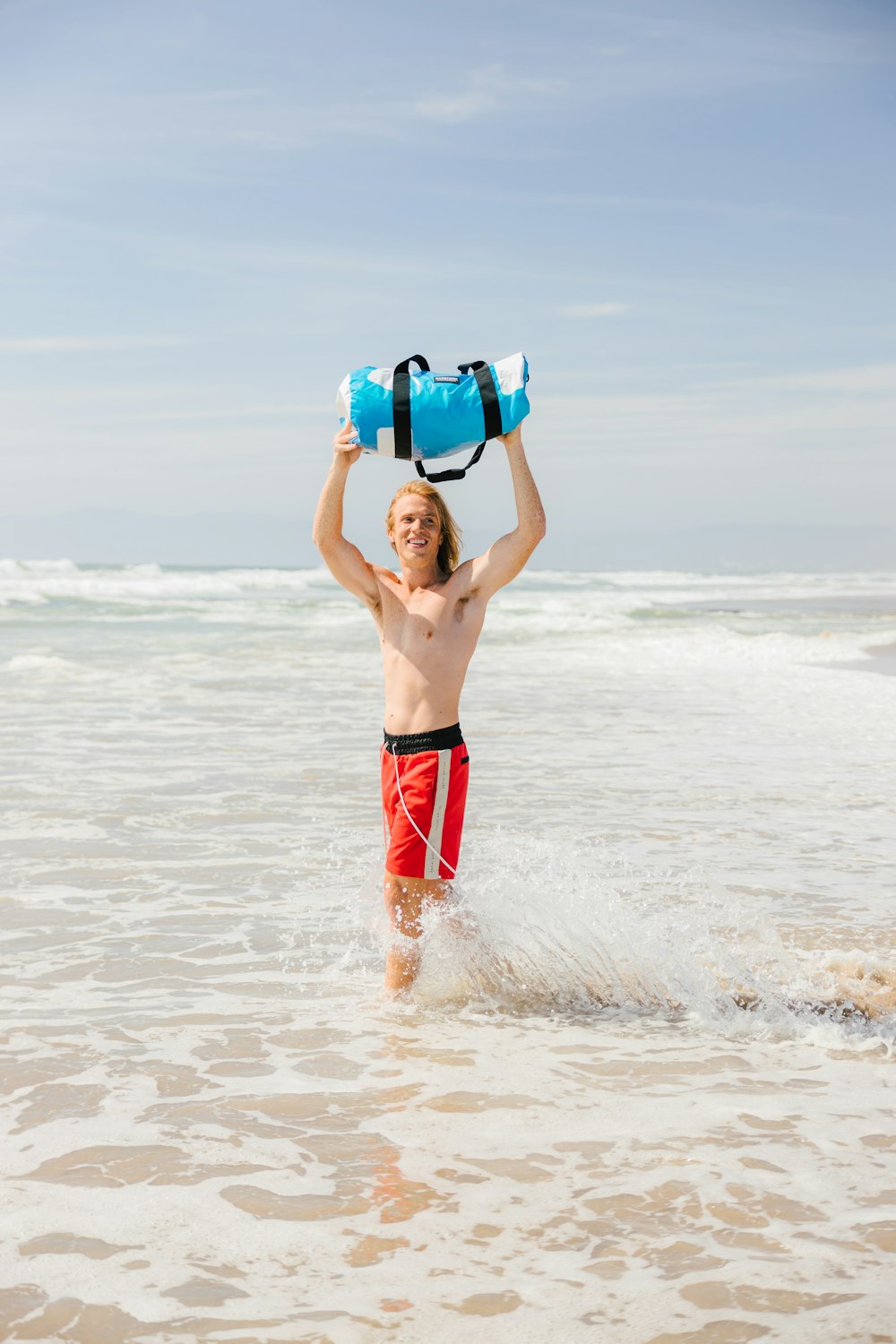 man in blue and red shorts on beach during daytime