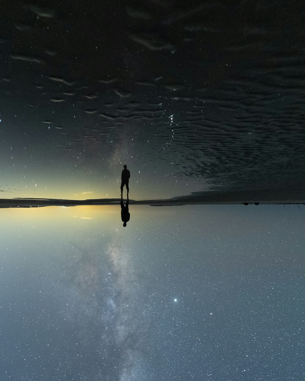 person walking on wet sand during daytime